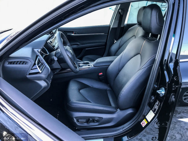 Водительской сидение при открытой двери в автомобиле Тойота Камри 2018 года выпуска
