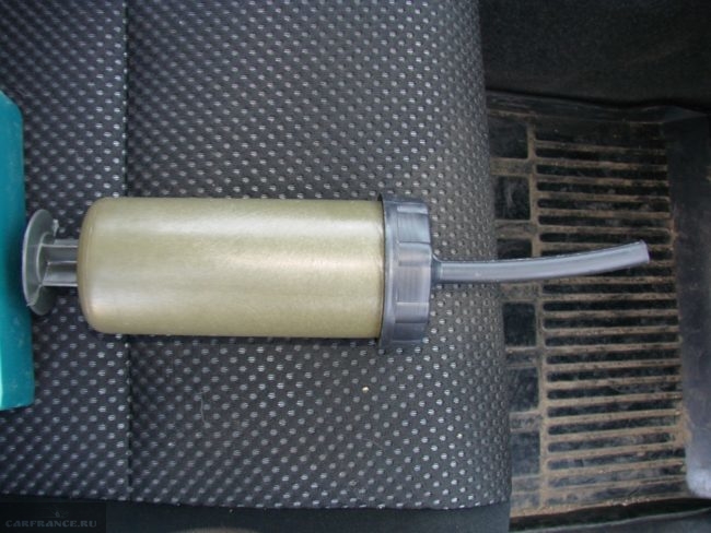 Шприц из пластика для залива нового масла в раздаточную коробку автомобиля на пассажирском переднем сидении Гранд Витара