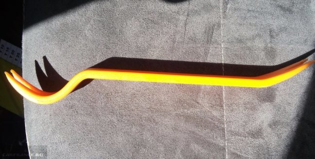 Желтая лопатка для снятия пластиковых клипс обшивки дверей на Фольскваген Поло седан
